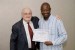 Dr. Nagib Callaos, General Chair, giving Prof. Masengo Ilunga the best paper award certificate of the session "Knowledge, Design and Modeling in Science, Education, and Technology." The title of the awarded paper is "Institutional Models of Open and Distance Learning: Comparison between Open University of the United Kingdom and University of South Africa."